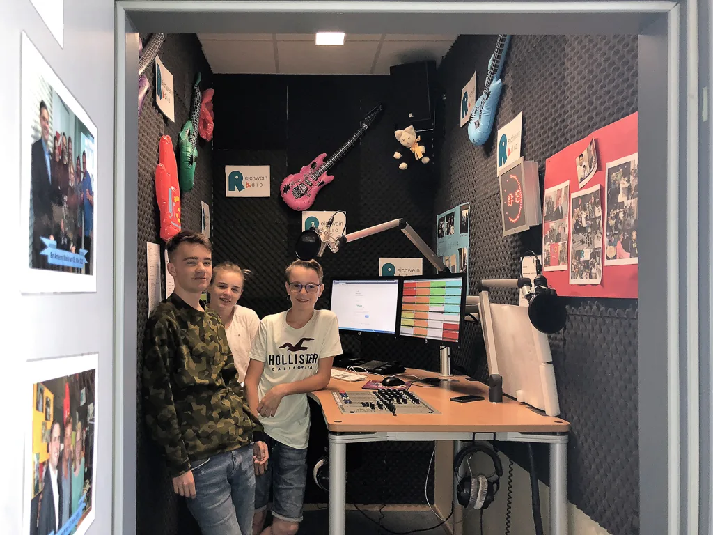 Jugendliche sitzen im Tonstudio am Mischpult.